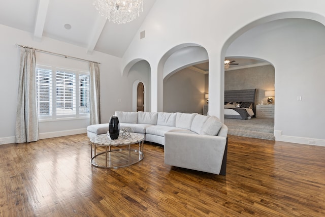 living room featuring ceiling fan with notable chandelier, beamed ceiling, dark hardwood / wood-style floors, and high vaulted ceiling