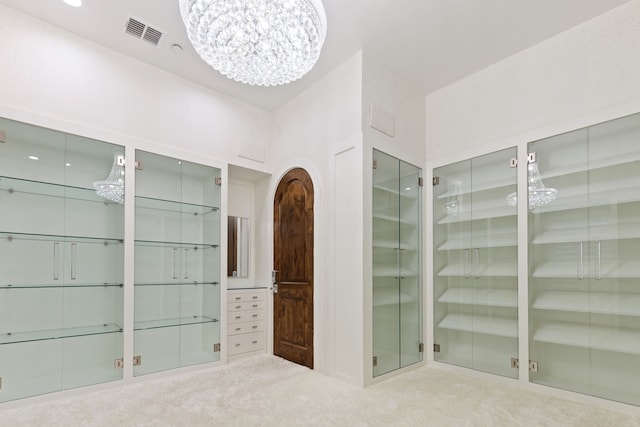 walk in closet with carpet floors and a chandelier