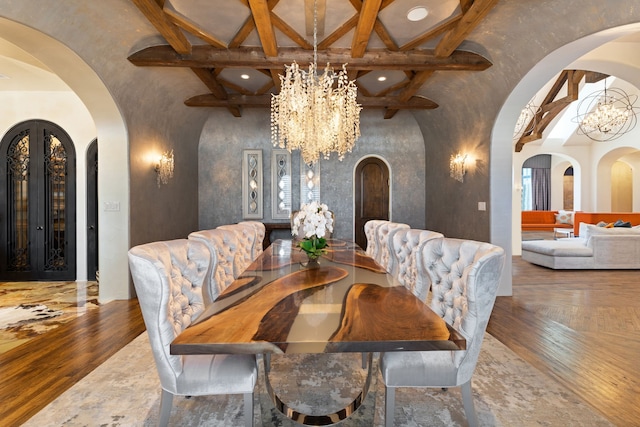 dining area with hardwood / wood-style floors, a notable chandelier, high vaulted ceiling, and beam ceiling