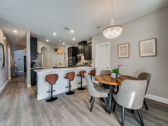 dining room featuring light wood-type flooring and an inviting chandelier