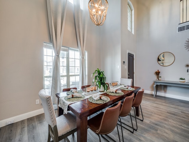 dining room featuring hardwood / wood-style floors and a high ceiling