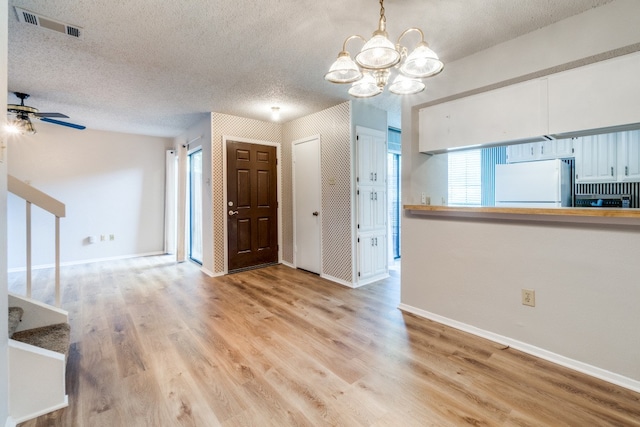 interior space featuring light hardwood / wood-style flooring, a textured ceiling, and ceiling fan