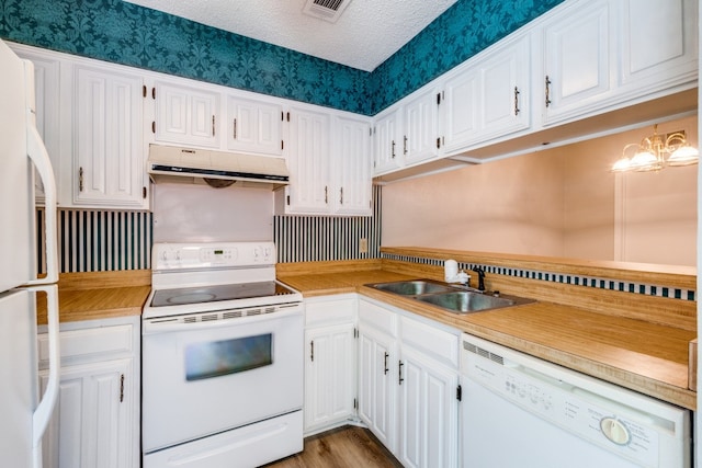 kitchen with white cabinets, white appliances, sink, light hardwood / wood-style flooring, and a textured ceiling