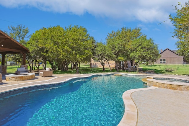 view of pool with a patio, a yard, and an in ground hot tub