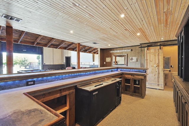 kitchen featuring lofted ceiling, a barn door, wooden ceiling, and light carpet