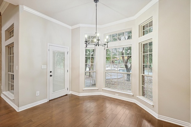 unfurnished dining area with ornamental molding, dark hardwood / wood-style floors, and a chandelier