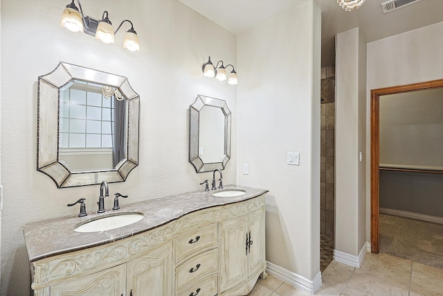 bathroom with tile patterned flooring, vanity, and a shower