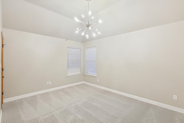 empty room featuring a chandelier, lofted ceiling, and light carpet