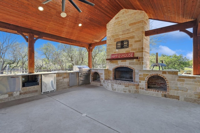 view of patio / terrace featuring an outdoor kitchen, area for grilling, ceiling fan, and an outdoor stone fireplace