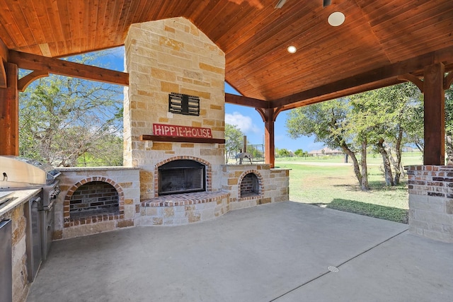 view of patio with area for grilling and an outdoor stone fireplace