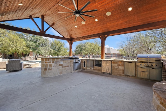 view of patio / terrace with an outdoor kitchen, area for grilling, ceiling fan, and a gazebo