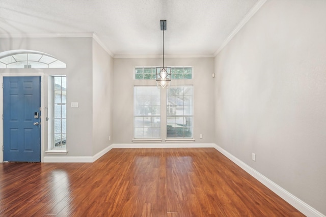 entrance foyer with hardwood / wood-style floors, an inviting chandelier, and ornamental molding