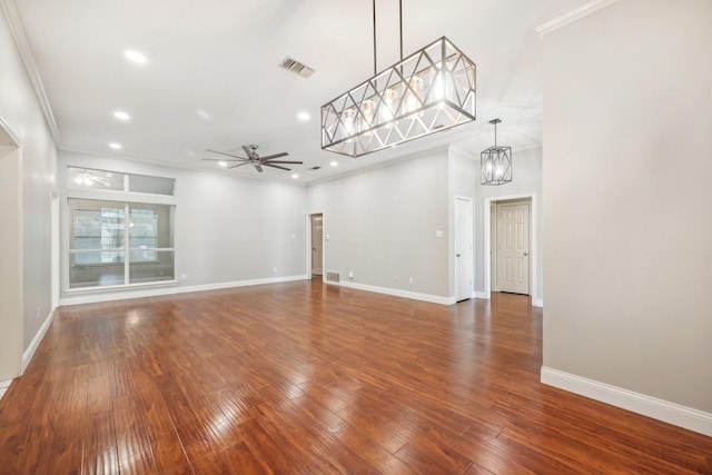 interior space with ceiling fan with notable chandelier, dark hardwood / wood-style floors, and crown molding