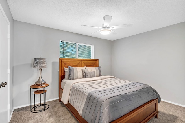 carpeted bedroom with ceiling fan and a textured ceiling