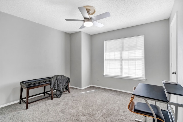 home office with ceiling fan, a textured ceiling, and light carpet