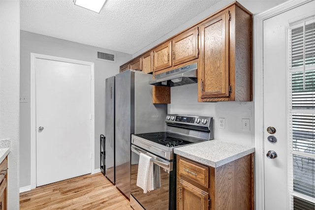 kitchen with a textured ceiling, light hardwood / wood-style floors, and stainless steel electric stove