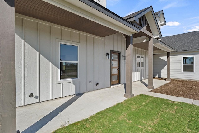 doorway to property featuring a patio area and a lawn