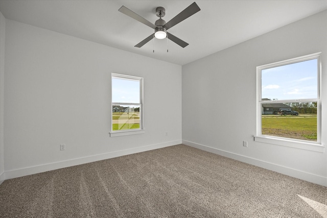 carpeted spare room featuring ceiling fan