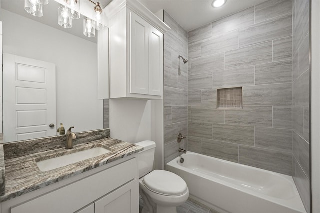 full bathroom with tiled shower / bath, vanity, and toilet