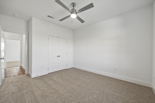 unfurnished bedroom with ceiling fan, carpet floors, and a closet