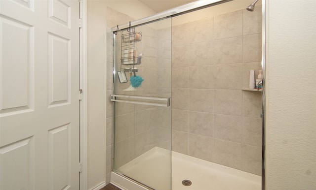 bathroom featuring a shower with door