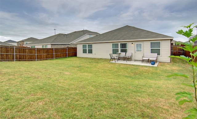 rear view of property with a lawn and a patio area