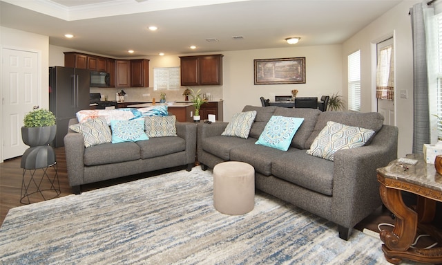 living room featuring light hardwood / wood-style flooring and crown molding