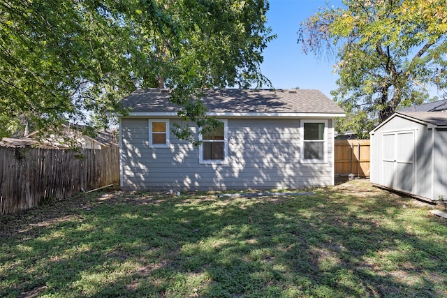 rear view of house featuring a yard and a shed