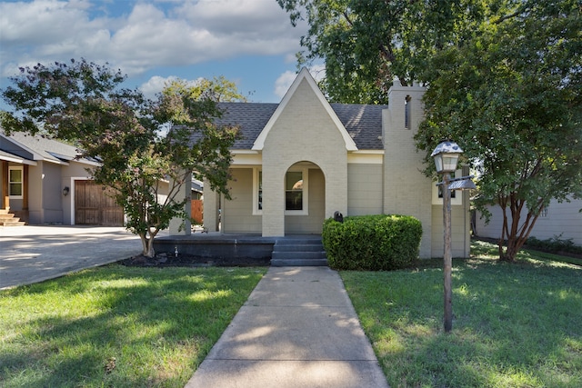 view of front of home featuring a garage, a porch, and a front lawn