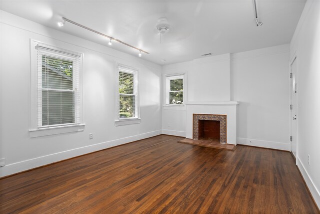 unfurnished living room with rail lighting, dark hardwood / wood-style floors, and ceiling fan