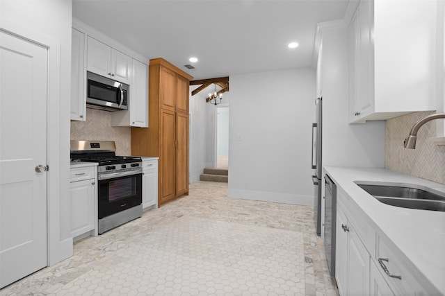 kitchen with sink, a notable chandelier, white cabinetry, decorative backsplash, and stainless steel appliances