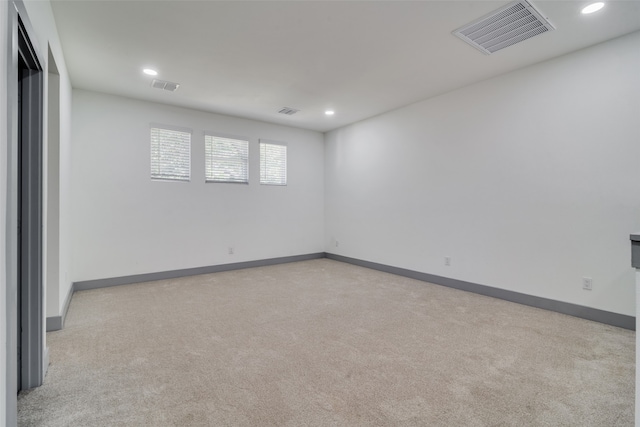 unfurnished room featuring light carpet