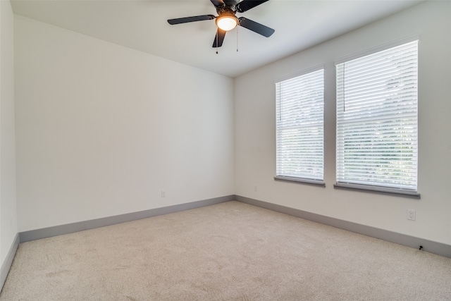 spare room featuring ceiling fan and light carpet