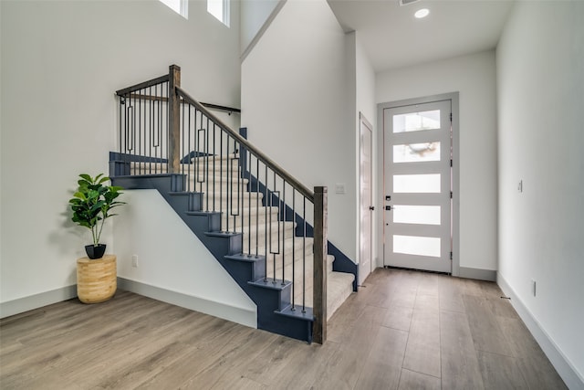 entrance foyer with hardwood / wood-style floors and a high ceiling