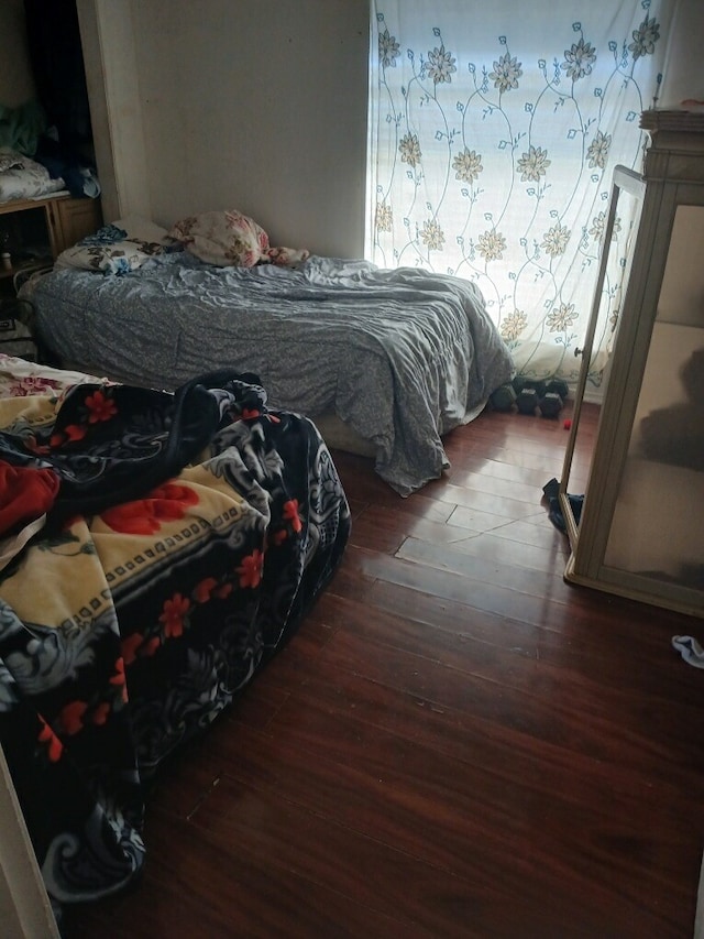 bedroom with dark hardwood / wood-style flooring