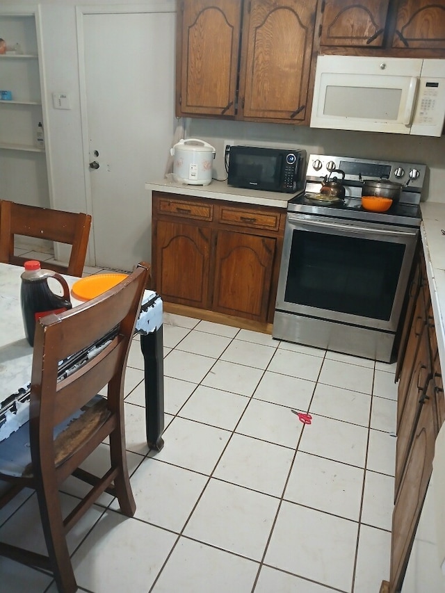 kitchen with light tile patterned floors and electric range