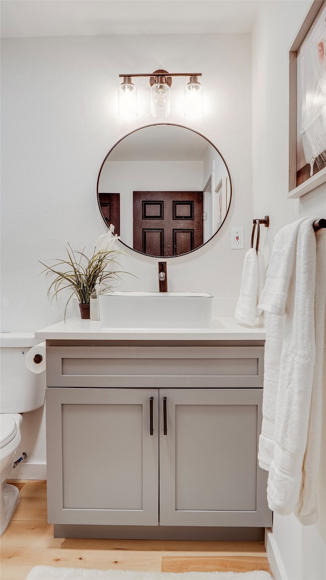 bathroom with vanity, toilet, and hardwood / wood-style flooring