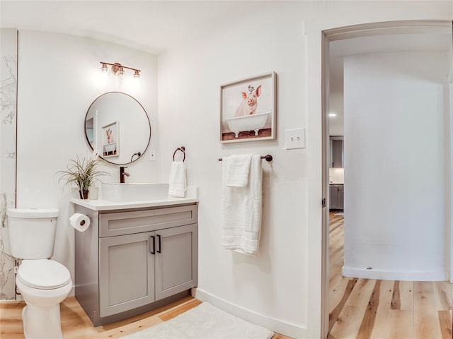 bathroom featuring wood-type flooring, vanity, and toilet