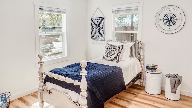 bedroom with multiple windows and hardwood / wood-style flooring