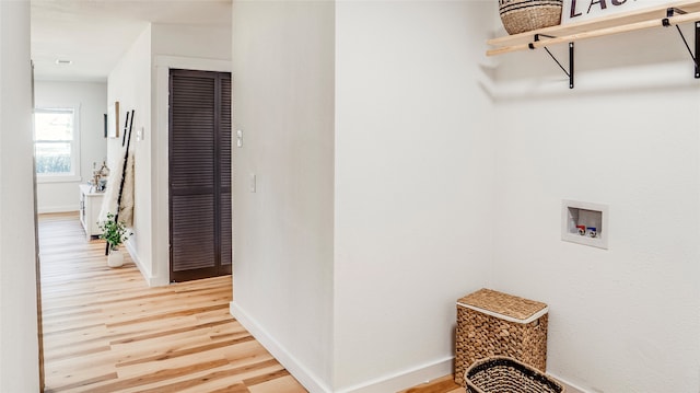 laundry area with wood-type flooring and hookup for a washing machine