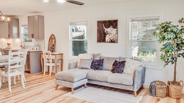 living room featuring a chandelier, light hardwood / wood-style floors, and sink