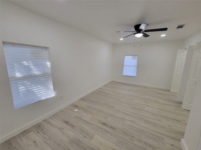 spare room with ceiling fan and light wood-type flooring