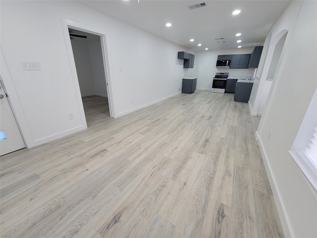 unfurnished living room with sink and light hardwood / wood-style floors