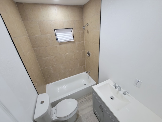 full bathroom featuring toilet, hardwood / wood-style floors, vanity, and tiled shower / bath