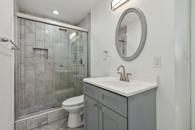 bathroom featuring tile patterned flooring, an enclosed shower, vanity, and toilet