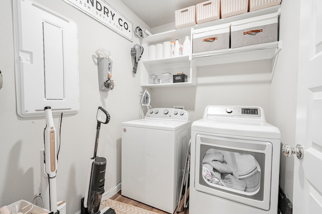 laundry room with light wood-type flooring and separate washer and dryer