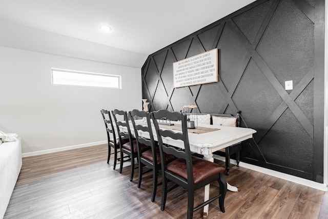 dining room featuring lofted ceiling and hardwood / wood-style flooring