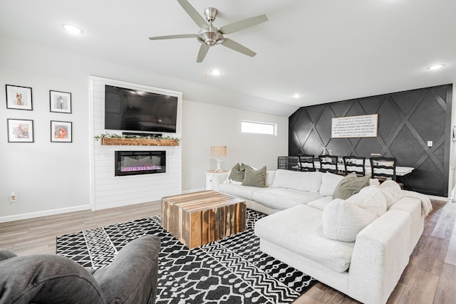 living room with a fireplace, ceiling fan, and hardwood / wood-style flooring