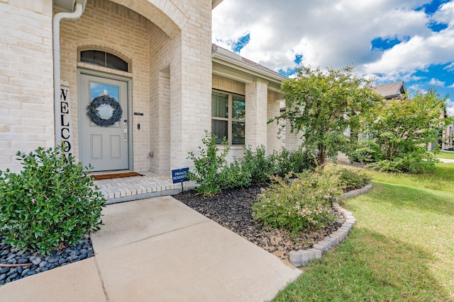 entrance to property featuring a lawn