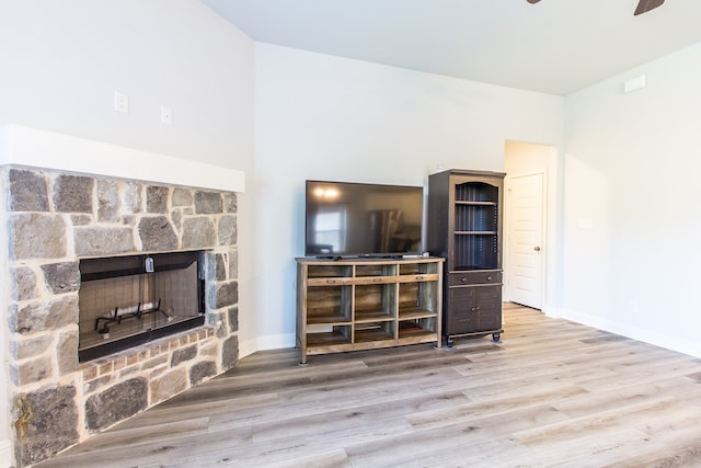 living room featuring ceiling fan, hardwood / wood-style flooring, and a fireplace